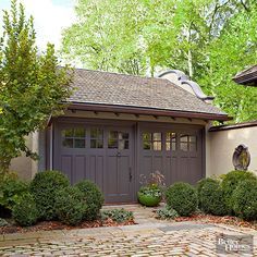 a house that has some plants in the front yard and bushes on the side of it