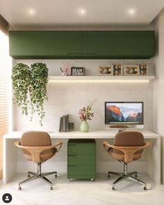 two office chairs sitting in front of a desk with a computer monitor on top of it