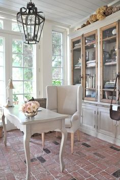 a dining room table and chairs in front of a china cabinet with glass doors on it