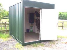 a green and white shed sitting on top of a grass covered field