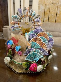 a decorative hat is sitting on a table in front of a couch and chair with flowers