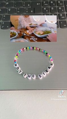 a laptop computer sitting on top of a desk with a bracelet that says nothing else