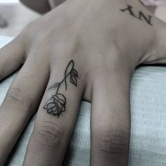 a woman's hand with a rose tattoo on it