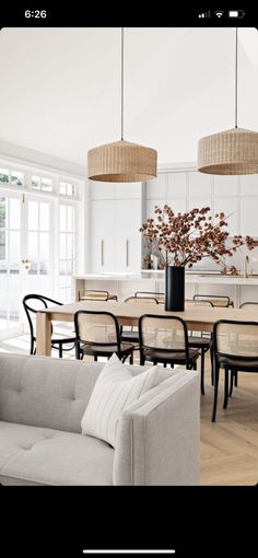 a living room filled with furniture next to a dining room table and chairs on top of a hard wood floor