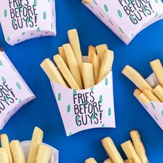 french fries are sitting in paper containers on a blue surface with the words fries before guys written on them