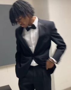 a man in a tuxedo is looking down