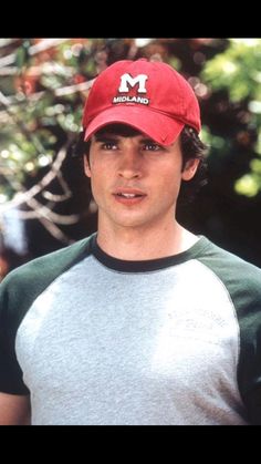 a young man wearing a red hat with the m on it's front and side