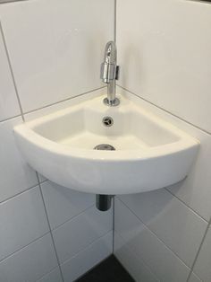 a white bathroom sink sitting under a faucet