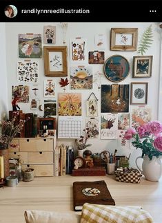 a room with many pictures on the wall and flowers in vases next to it