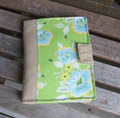 a green and blue flowered cloth on top of a wooden bench