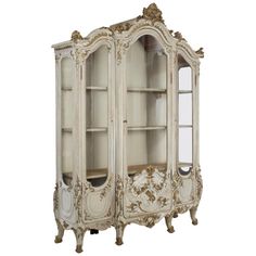 an antique white china cabinet with ornate carvings