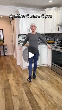 a woman standing in a kitchen with her arms out