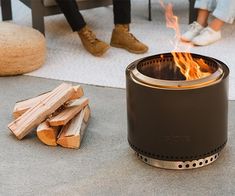 two people sitting around a fire pit on the ground