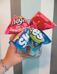 a person holding up some candy in a jar