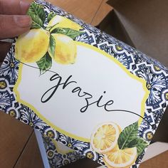 a person holding up a box with some lemons on it and the word yasie written in black ink