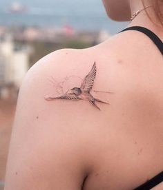 a woman with a bird tattoo on her shoulder