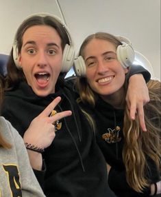 three girls wearing headphones and pointing at the camera