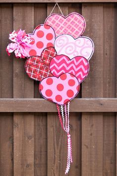 a heart shaped decoration hanging on the side of a wooden fence