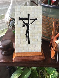 a wooden stand with a cross on it next to potted plants and other items