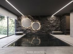 an indoor swimming pool with two circular mirrors on the wall