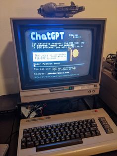 an old computer sitting on top of a desk next to a keyboard and monitor screen