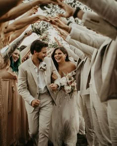 a bride and groom walking through a group of people