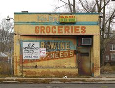 an old building that has been painted yellow and blue with some signs on the side