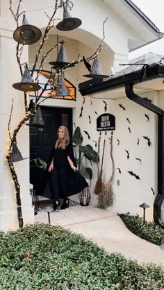 a woman standing in the doorway of a house decorated for halloween with decorations and bats