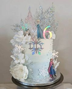 a frozen princess themed birthday cake with frosting and flowers on top is shown in front of a white background