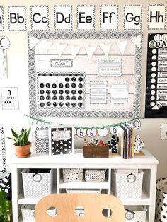 a white desk topped with a wooden chair next to a wall covered in black and white letters