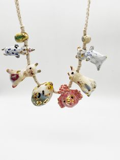 three necklaces with animals hanging from them