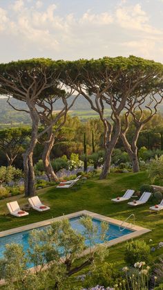 an outdoor pool surrounded by trees and lawn chairs