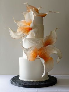 a three tiered white cake with orange flowers on top