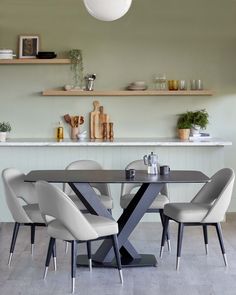 a dining room table with white chairs around it