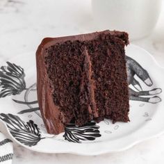 a piece of chocolate cake sitting on top of a white plate next to a cup