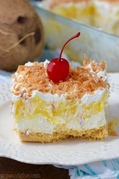 a piece of cake sitting on top of a white plate next to a coconut shell