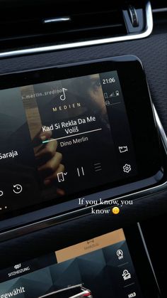 an electronic device is shown in the center console of a car, with music playing on it