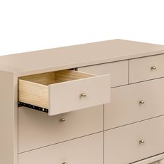 a white dresser with two drawers on each side and an open drawer in the middle