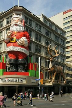 a large christmas decoration in the middle of a city street with people walking around it