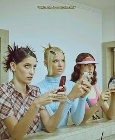 three women are looking at their cellphones while sitting on a ledge in front of them