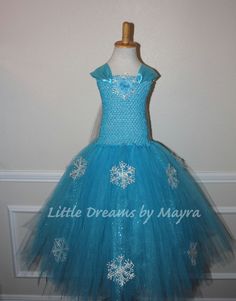 a blue dress with white snowflakes on the bottom, and a bow at the waist