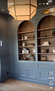 a room with two blue bookcases and a light fixture above the bookshelf