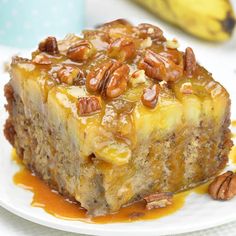 a piece of cake on a plate with pecans and caramel drizzle