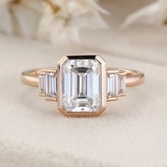 an emerald cut diamond ring with baguettes on the sides and three side stones