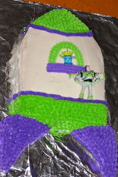 a cake that is shaped to look like a toy story book with buzz lightyear on it