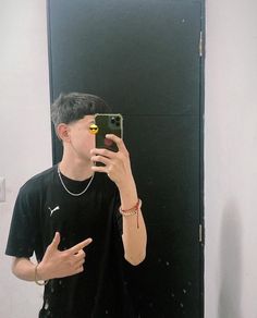 a young man taking a selfie in front of a mirror with his cell phone