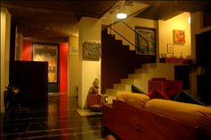 a living room filled with lots of furniture next to a stair case in front of a red door