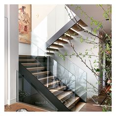 there is a stair case with glass railings on the top and bottom floors in this house