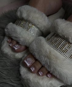 a woman's feet with white and silver glittered toenails