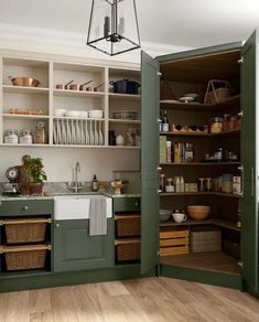 an open pantry with lots of dishes and baskets on the shelves in front of it